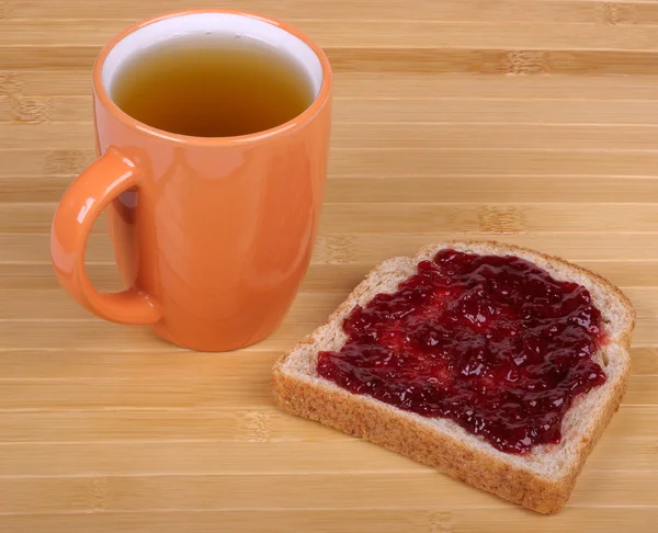 Чашка чая и сэндвич с джемом — стоковое фото