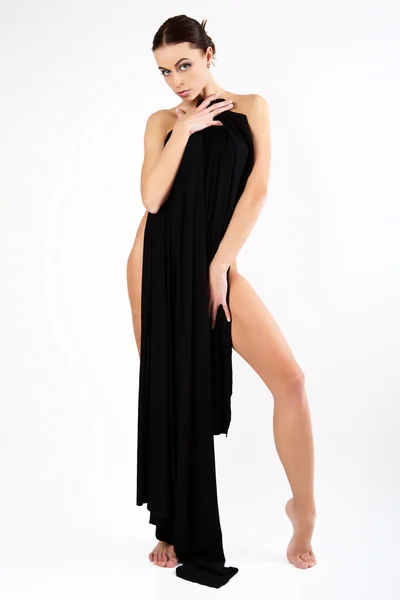 Vacker ung kvinna som är täckt med svart tyg. — Stockfoto