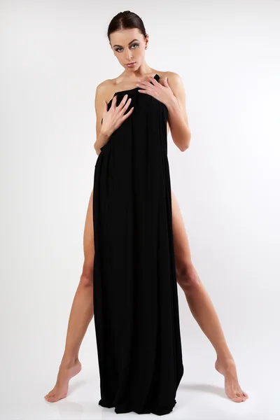 Hermosa mujer joven está cubierta de tela negra . — Foto de Stock