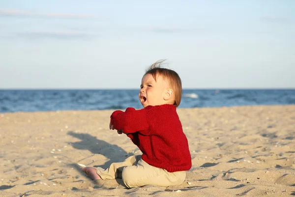 Petit garçon assis sur la plage de la mer . — Photo
