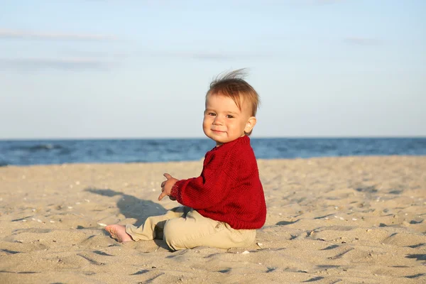 Menino sentar-se na praia do mar . — Fotografia de Stock