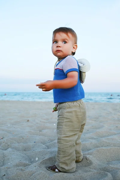 Babyjongen draait op het strand. — Stockfoto