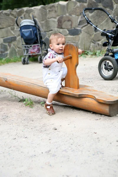 De kleine jongen op een speelplaats. — Stockfoto