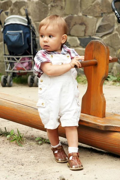De kleine jongen op een speelplaats. — Stockfoto