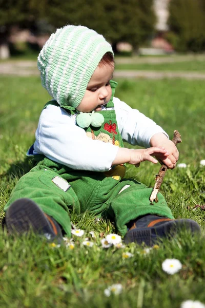 Um rapazinho com um pau de madeira . — Fotografia de Stock