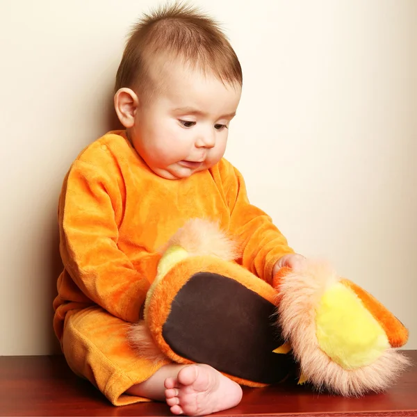かわいい赤ちゃんの少年の幼児座ってとスリッパを手で押し. — ストック写真