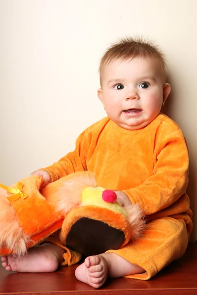 かわいい赤ちゃんの少年の幼児座ってとスリッパを手で押し. — ストック写真
