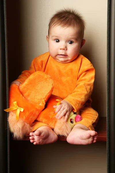 Lindo bebé niño sentado y sosteniendo zapatillas en la mano . —  Fotos de Stock