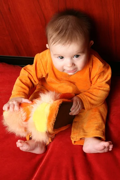 Söt baby pojke barn sitta och hålla tofflor i hand. — Stockfoto