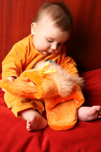 Dziecko ładny chłopiec maluch siedzi i trzymając w ręku kapcie. — Zdjęcie stockowe