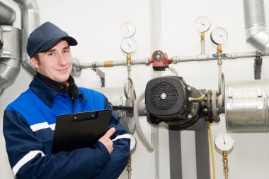 Heating engineer in boiler room clipart