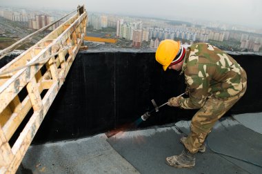 Flat roof covering works with roofing felt clipart