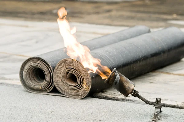 Tar roofing felt roll and blowpipe with flame — Stock Photo, Image
