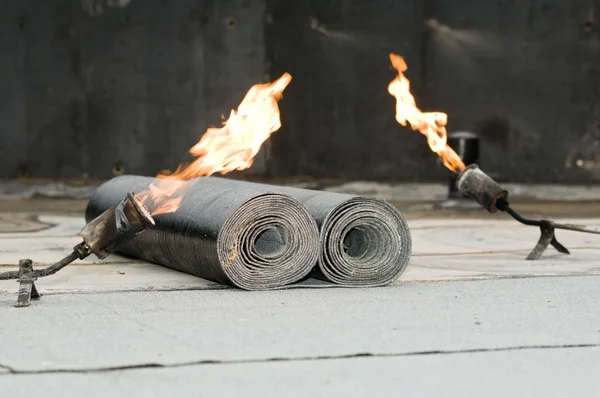 Tar roofing felt roll and blowpipe with flame — Stock Photo, Image