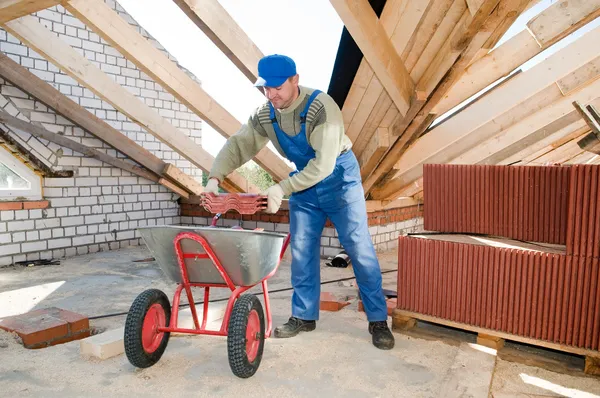 Construtor de telhados e carrinho de mão com telha de barro — Fotografia de Stock