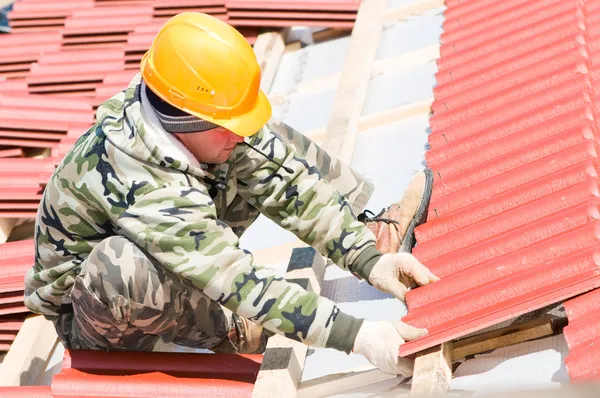 Builder roofer med röda plattsättning — Stockfoto