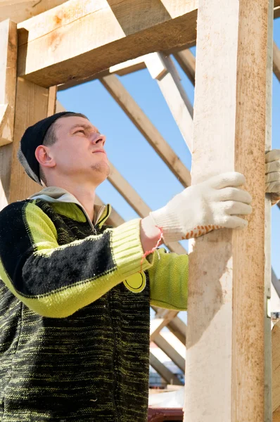 Builder arbetar med nivå och timmer ombord — Stockfoto