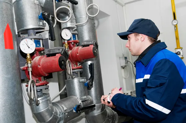 Heating engineer in boiler room Royalty Free Stock Images