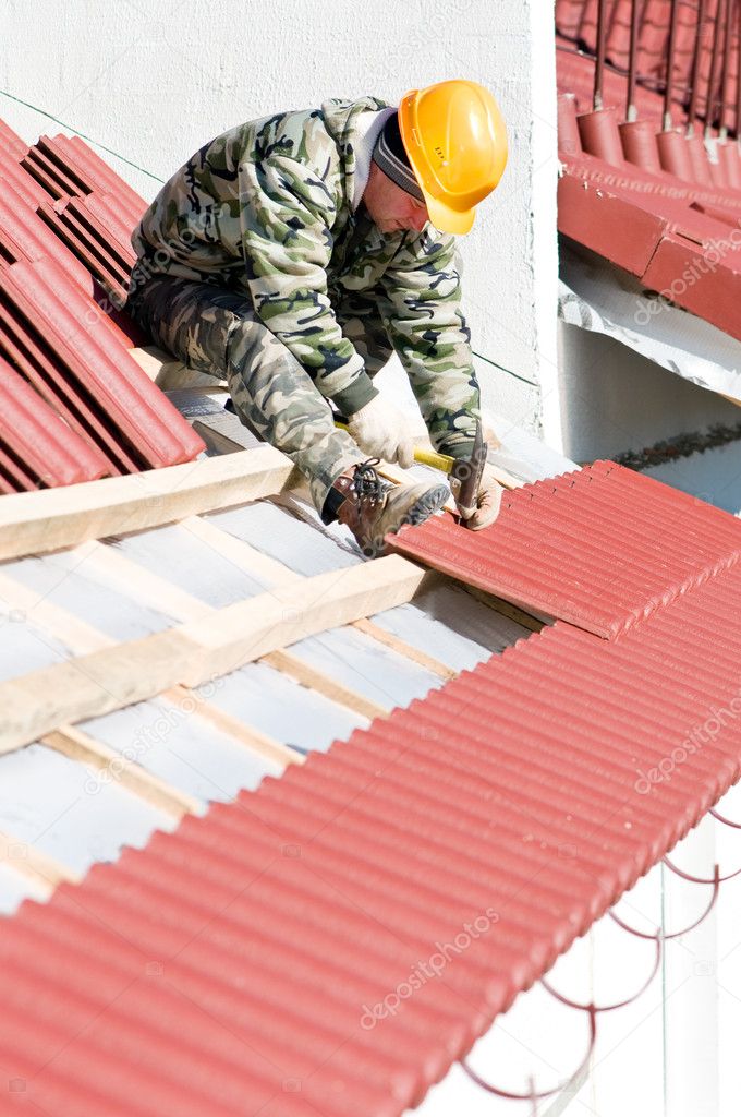 Roofer nailing clay tile