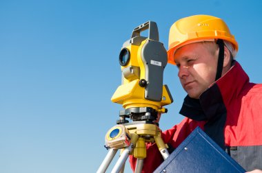 Surveyor looking at the thedolite clipart