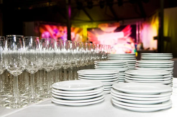 Белые тарелки и стебельное стекло на вечеринке — стоковое фото