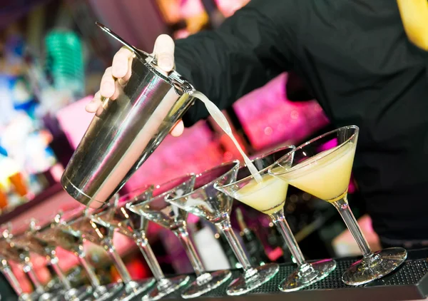 Barman’s hand with shaker and cocktails — Stock Photo, Image