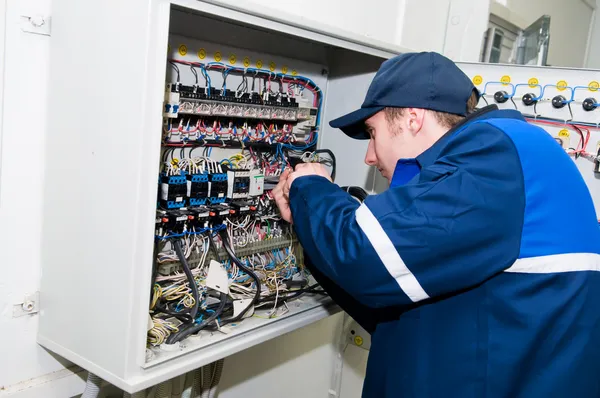 Eletricista em trabalho de ajuste de tensão — Fotografia de Stock