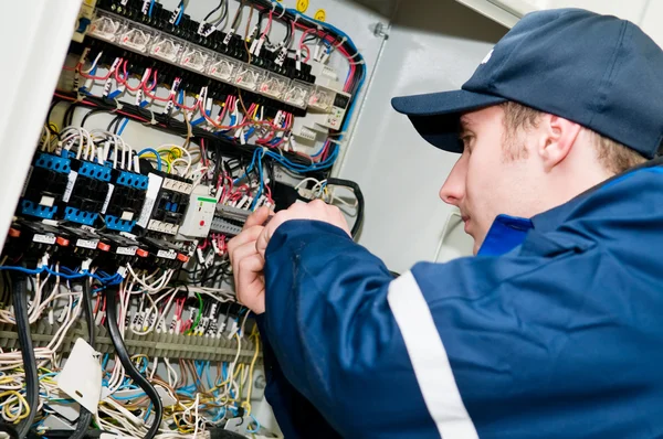 Eletricista em trabalho de ajuste de tensão — Fotografia de Stock