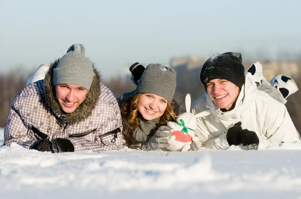 Glimlachend jonge liggen in sneeuwjacht — Stockfoto