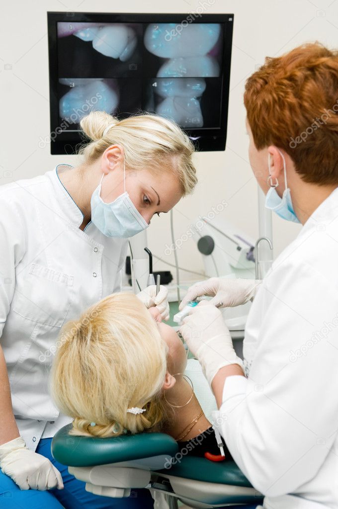 Dentist doctors at teeth treatment work