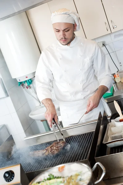 Šéfkuchař smažení hovězí steak na grilu — Stock fotografie