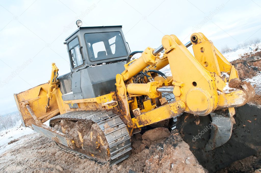 Bulldozer loader at winter frozen soil excavation works