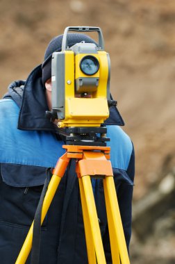 Surveyor works with theodolite tacheometer clipart