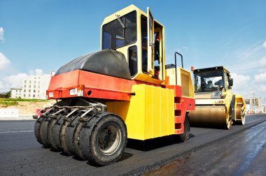 Pneumatic asphalt roller at work clipart