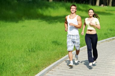 Young man and woman jogging outdoors clipart