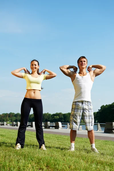 Jovem e mulher fazendo exercícios de alongamento — Fotografia de Stock