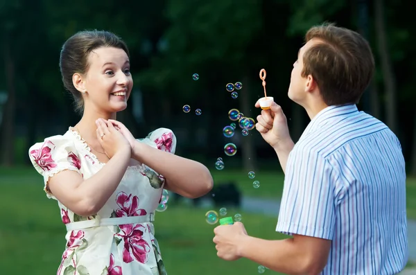 Felice coppia soffiando bolle di sapone — Foto Stock