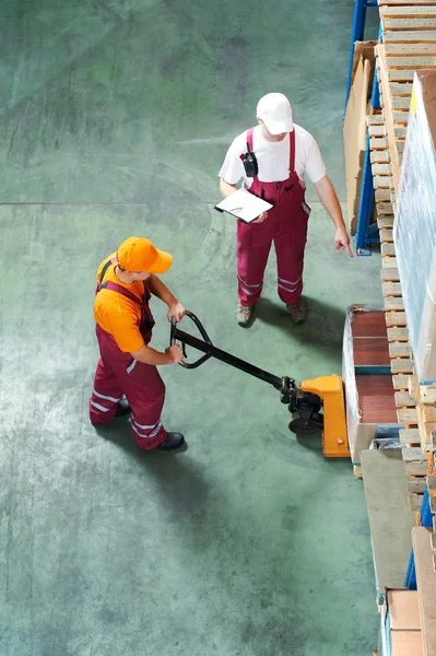 Warehouse workers with fork pallet truck stacker — Stock Photo, Image