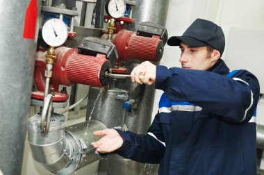 Heating engineer repairman in boiler room clipart