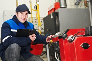 Heating engineer repairman in boiler room clipart