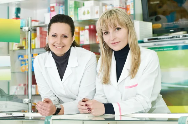 Two Pharmacy chemist women in drugstore — Stockfoto