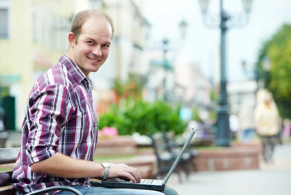 Χαμογελαστός άνθρωπος με laptop — Φωτογραφία Αρχείου