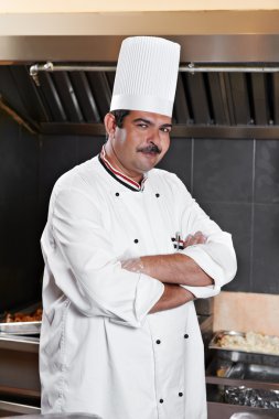 Chef in uniform at kitchen clipart