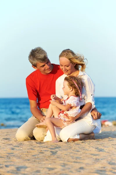 Семья с ребенком на морском пляже — стоковое фото