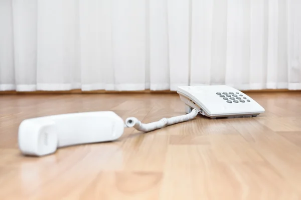 White telephone on the parquet floor — Stock Photo, Image