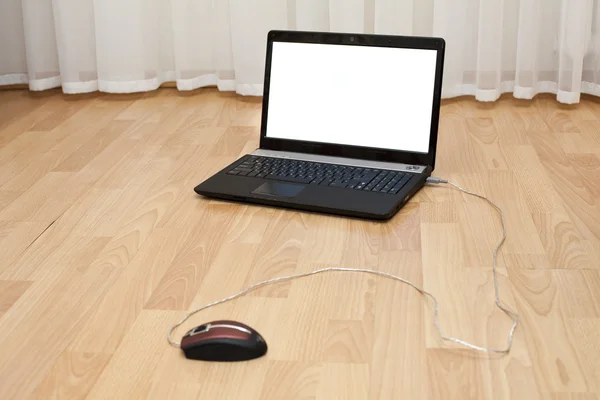 Ordinateur portable ouvert et une souris d'ordinateur sur le sol de la pièce — Photo