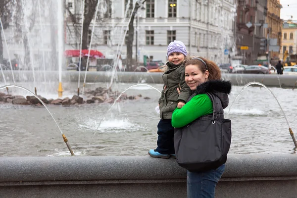 Madre y su pequeña niña al aire libre en la ciudad cerca de la fuente —  Fotos de Stock