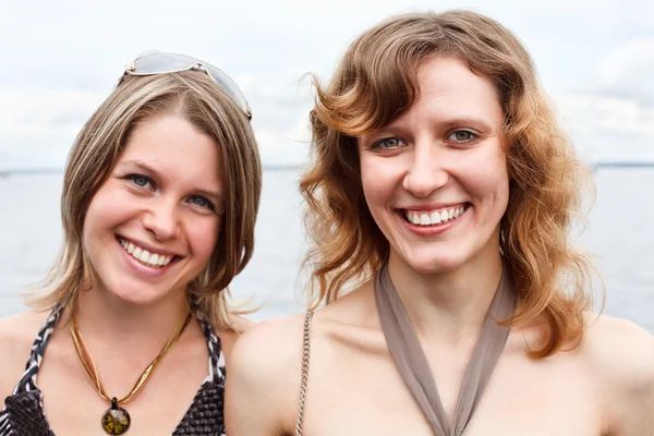 两个漂亮的年轻女人站在一起和微笑 — 图库照片