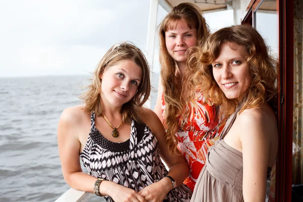 Drei schöne junge Frauen ein Kaukasier, die zusammen auf dem Deck von y stehen — Stockfoto