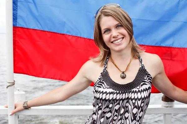 Una joven rusa hermosa de pie bajo la bandera de Rusia —  Fotos de Stock